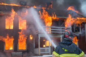 燃え盛る共同住宅と消防士